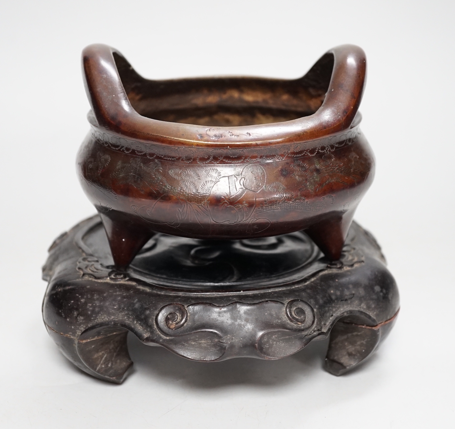 A Chinese bronze censer, with engraved detail, on hardwood stand, censer 16cm diam.